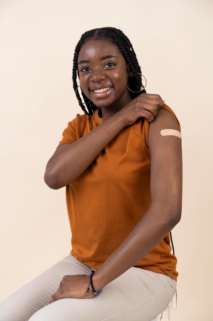 Woman showing sticker on arm after getting a vaccine