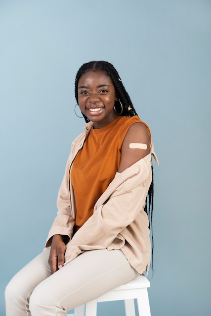 Woman showing sticker on arm after getting a vaccine