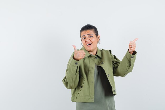 woman showing thumbs up in jacket, t-shirt and looking confident