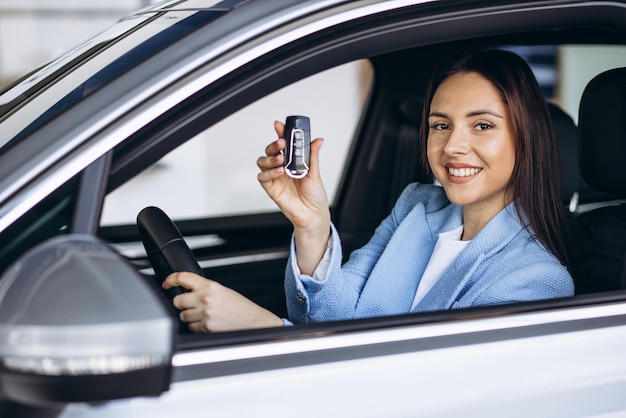 Woman sits in car and holding car keys