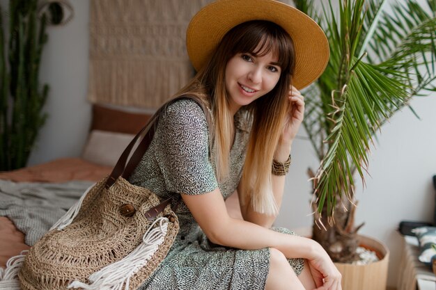 Woman sitting on bed in her boho apartment