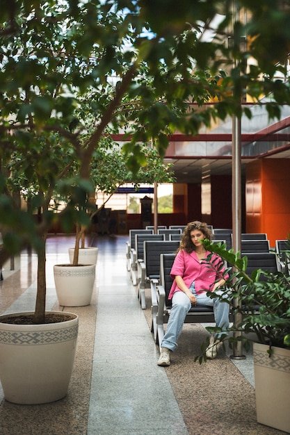 Free Photo woman sitting on bench full shot