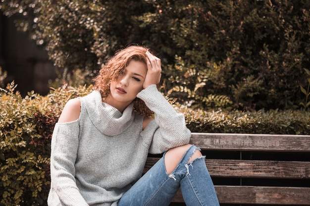 Free photo woman sitting on bench in park