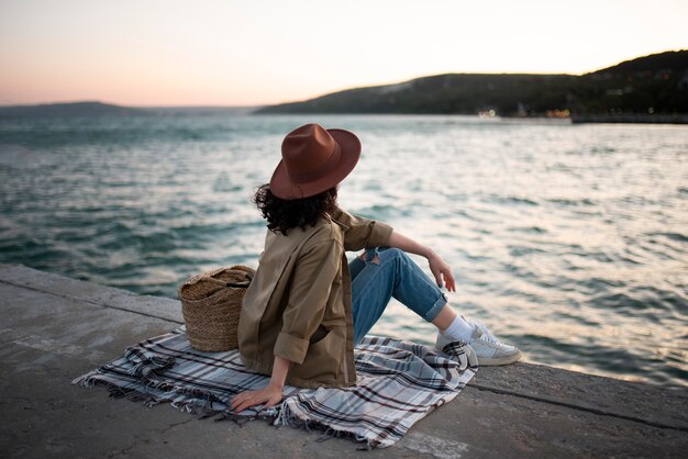 Woman sitting on blanket full shot