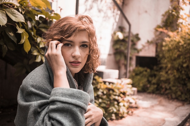 Free photo woman sitting on board in coat