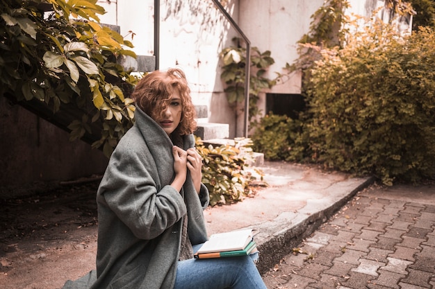 Free photo woman sitting on board and holding coat's collar