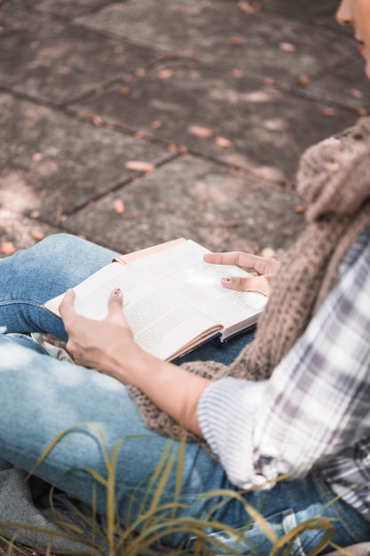 Free photo woman sitting on board with book in sunny day