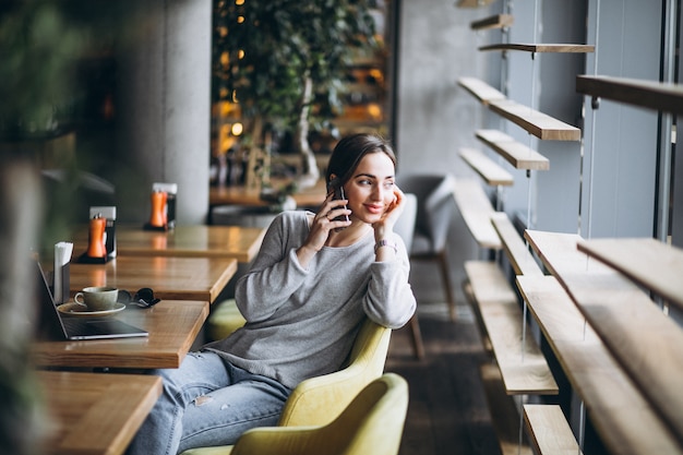 Free Photo woman sitting in a cafe drinking coffee and working on a computer