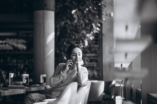 Free Photo woman sitting in a cafe drinking coffee and working on a computer