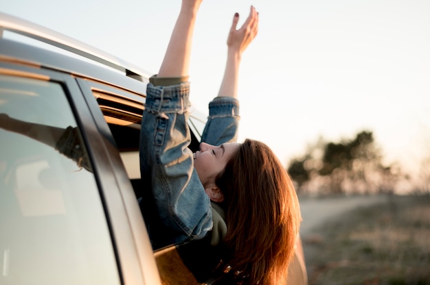 Woman sitting in a car with her hands and head outdoors