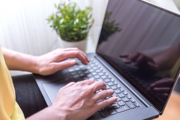 Free Photo woman sitting on a chair using a laptop on her lap