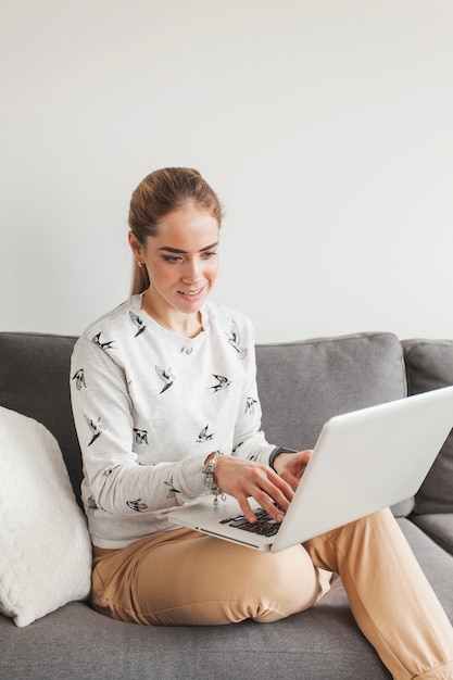 Woman sitting on couch with laptop