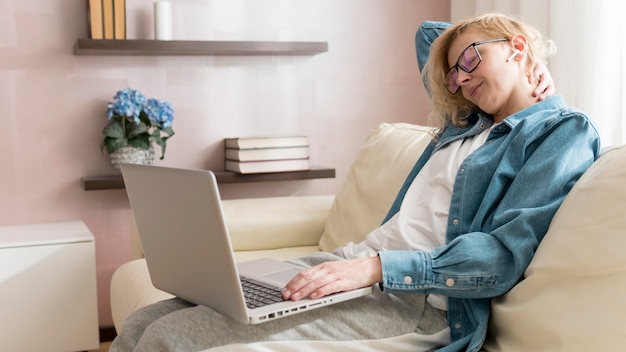 Woman sitting on couch and working on laptop