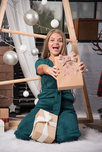 Woman sitting on the floor at home with Christmas presents