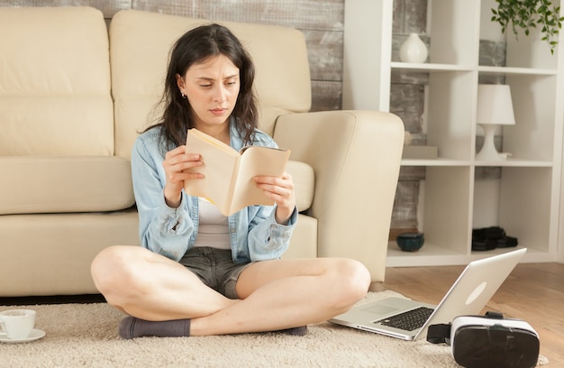 Woman sitting on floor reading a book