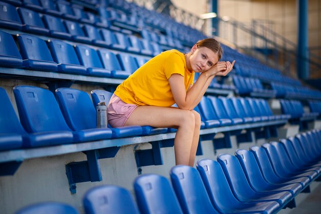 Woman sitting on grandstand side view