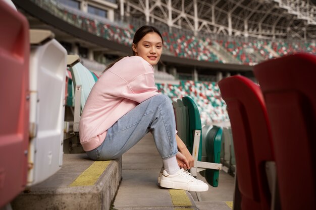 Woman sitting on grandstands full shot