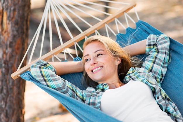 Woman sitting in hammock and looking away