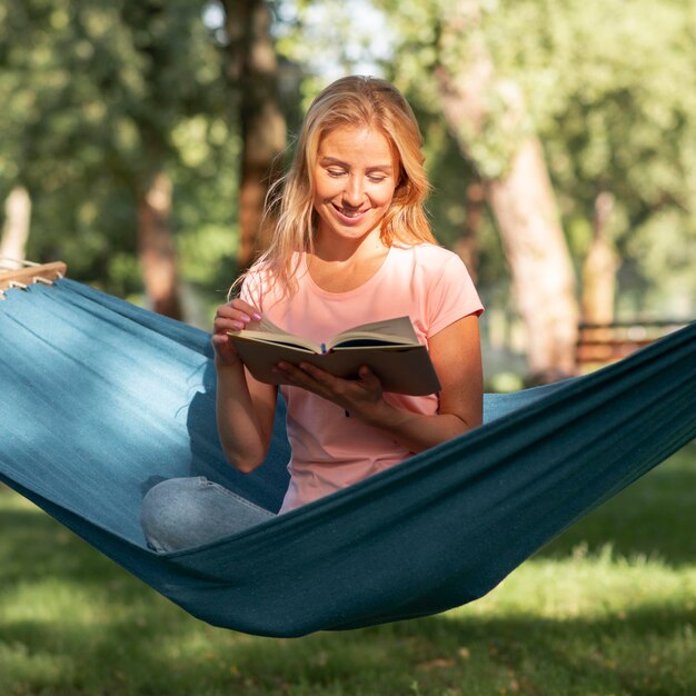 Woman sitting in hammock and reads