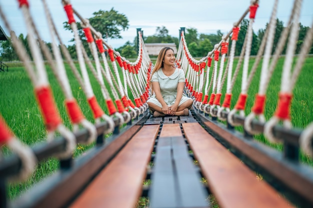 Woman sitting happily on a wooden bridge