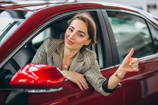 Free Photo woman sitting i car in a car showrrom