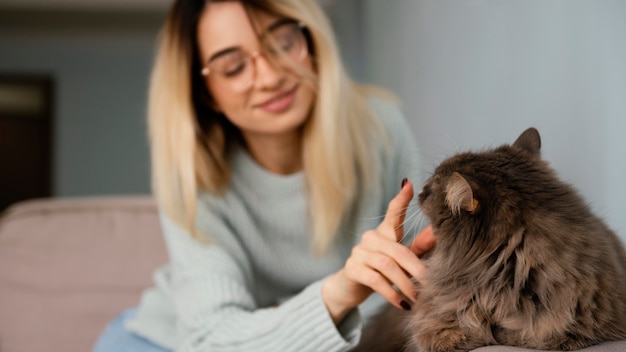 Free photo woman sitting indoors with her cat