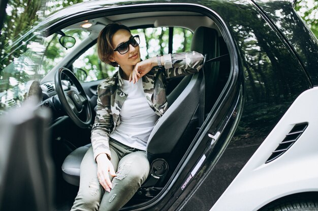 Woman sitting inside a car in the forest