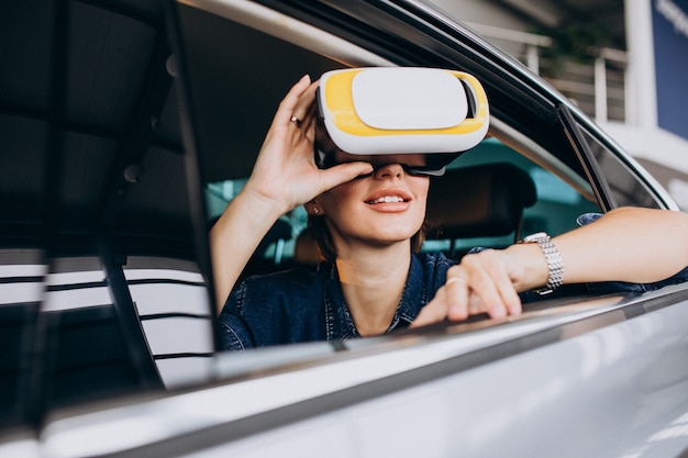 Free photo woman sitting inside a car wearing vr glasses