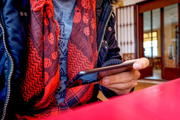 Woman sitting and looking through something on a modern smartphone