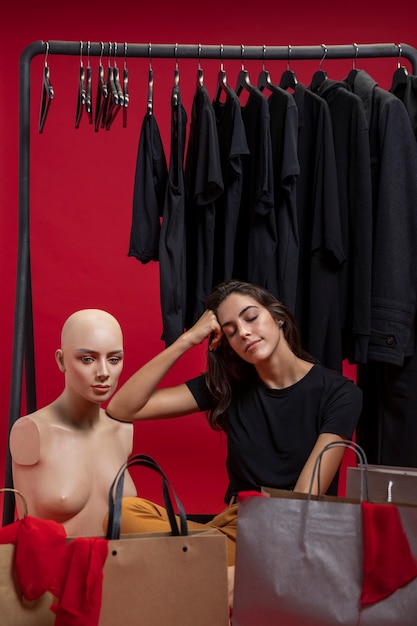 Free Photo woman sitting next to mannequin 