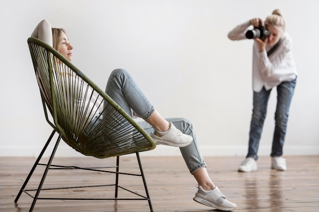 Free photo woman sitting and photographer taking photos