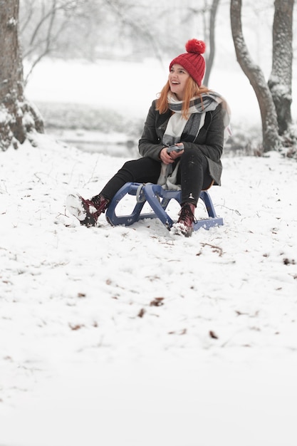 Woman sitting on a sleigh outdoors