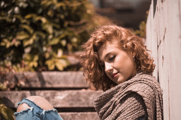 Free photo woman sitting on steps with bending head