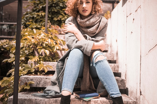 Free photo woman sitting on steps with crossing hands