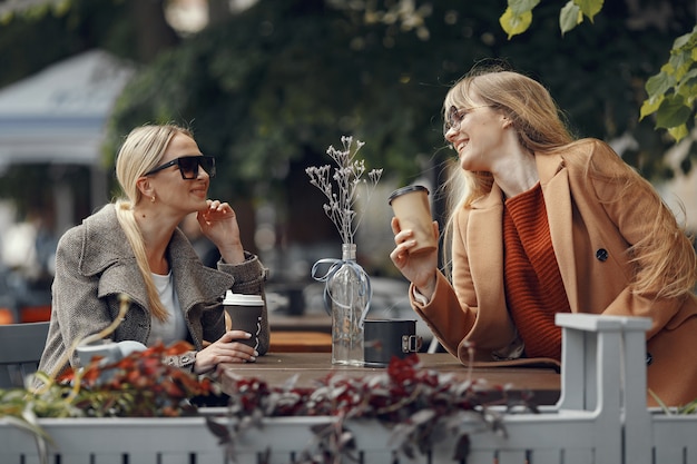 Free Photo woman sitting in a summer city and drinking coffee