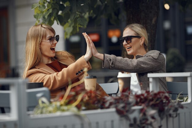 Woman sitting in a summer city and drinking coffee