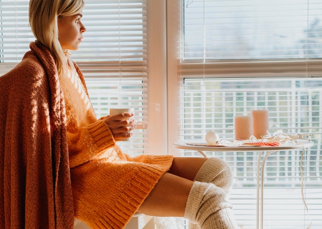 Free photo woman sitting at a table with a cup of tea