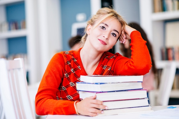 Free photo woman sitting with books in library