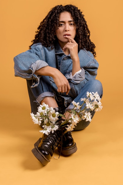 Woman sitting with flowers in boots