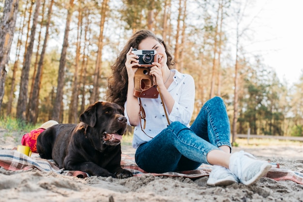 Free photo woman sitting with her dog in nature