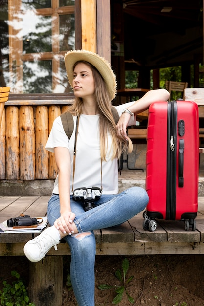 Free photo woman sitting with her luggage and looking away