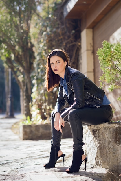 Woman sitting with high heels on a stone bench