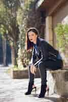 Free photo woman sitting with high heels on a stone bench