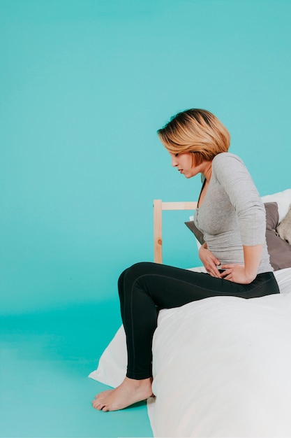 Free Photo woman sitting with hurting stomach