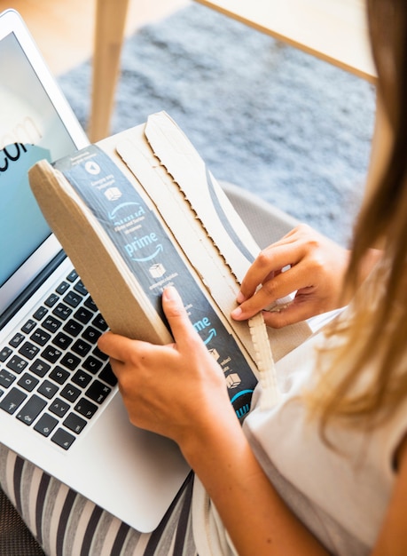 Free Photo woman sitting with laptop and opening delivery