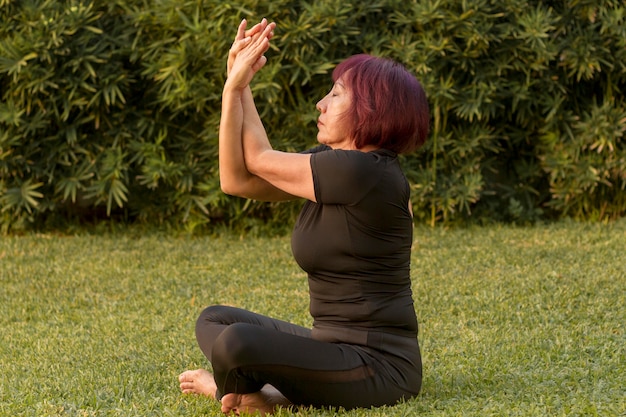 Woman sitting in yoga position and doing arms exercises