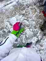 Free photo woman in ski clothes holding her hand on an icy stone in carpathians the toaca peak romania