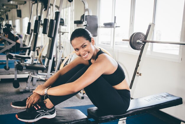 Woman smiling sitting on a weight machine