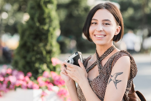 Woman smiling with camera outdoors