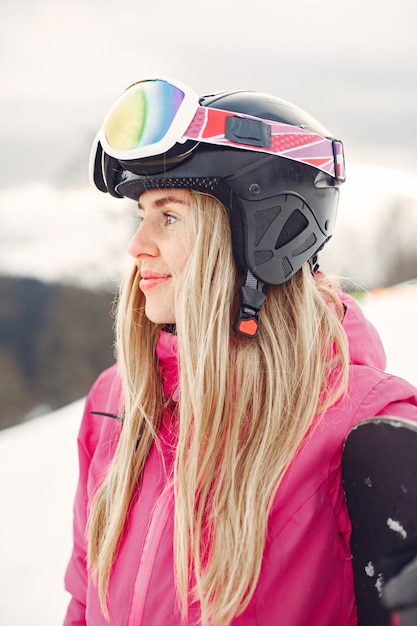 Free Photo woman in snowboard suit. sportswoman on a mountain with a snowboard in the hands on the horizon. concept on sports